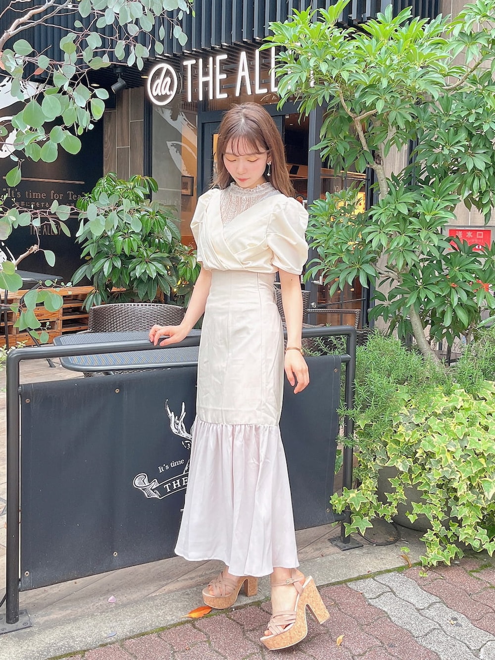 ベージュ系のサンダル、ホワイト系のスカート、ホワイト系のTシャツ/カットソーを着用したレディースの春コーディネートの2枚目の写真