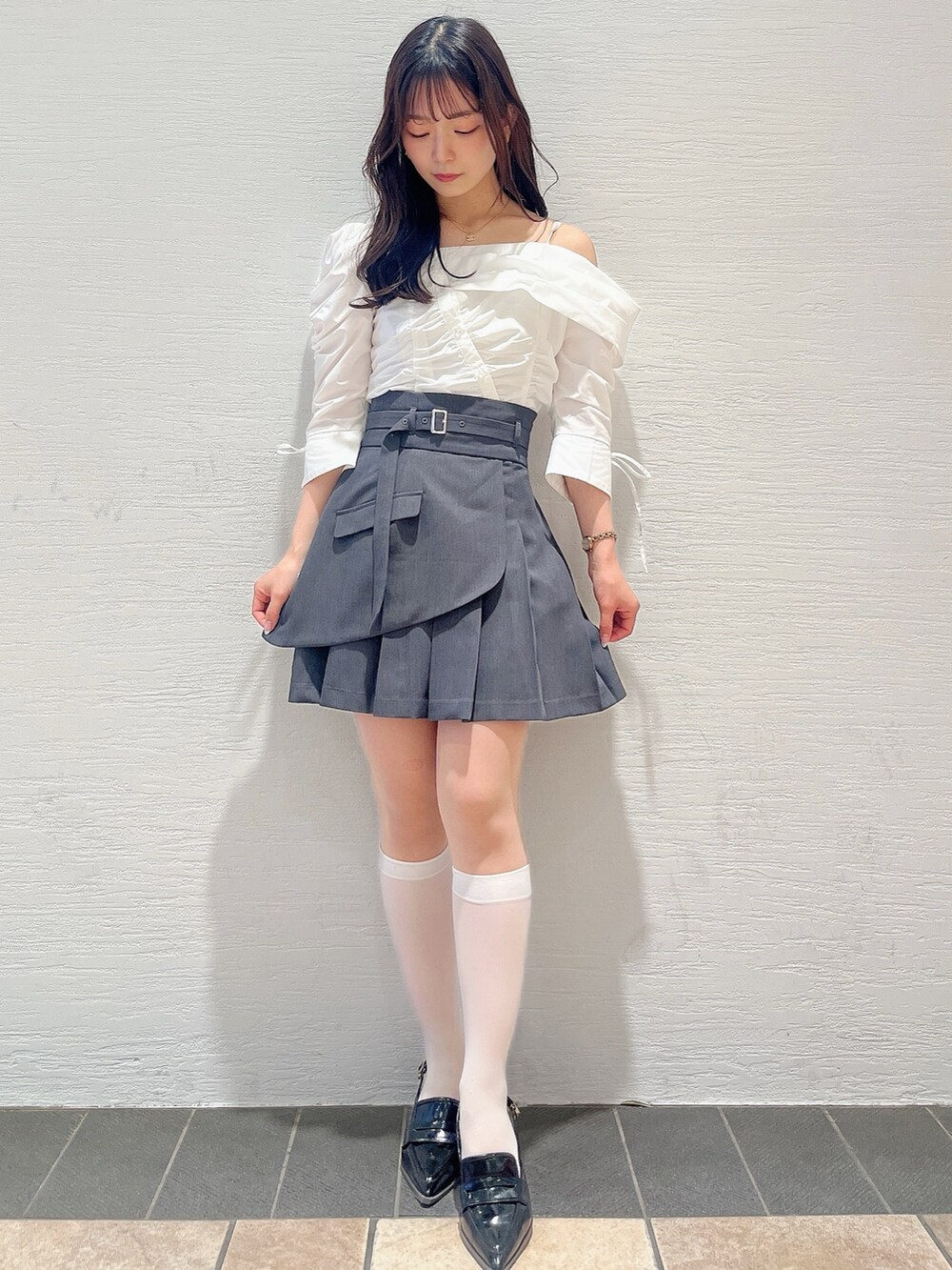 ホワイト系のシャツ/ブラウス、グレー系のスカート、ブラック系のローファーを着用したレディースの春コーディネートの2枚目の写真