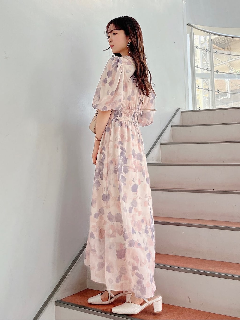 ピンク系のワンピース、ホワイト系のパンプス、ベージュ系のショルダーバッグを着用したレディースの春コーディネートの2枚目の写真