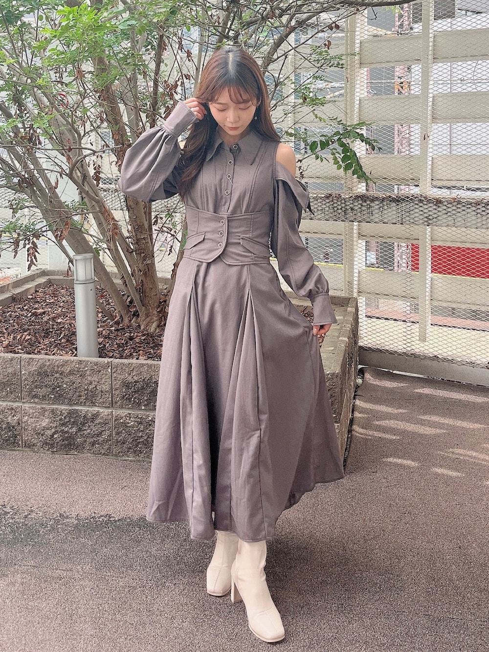 グレー系のワンピース、ホワイト系のブーツを着用したレディースの秋コーディネートの2枚目の写真