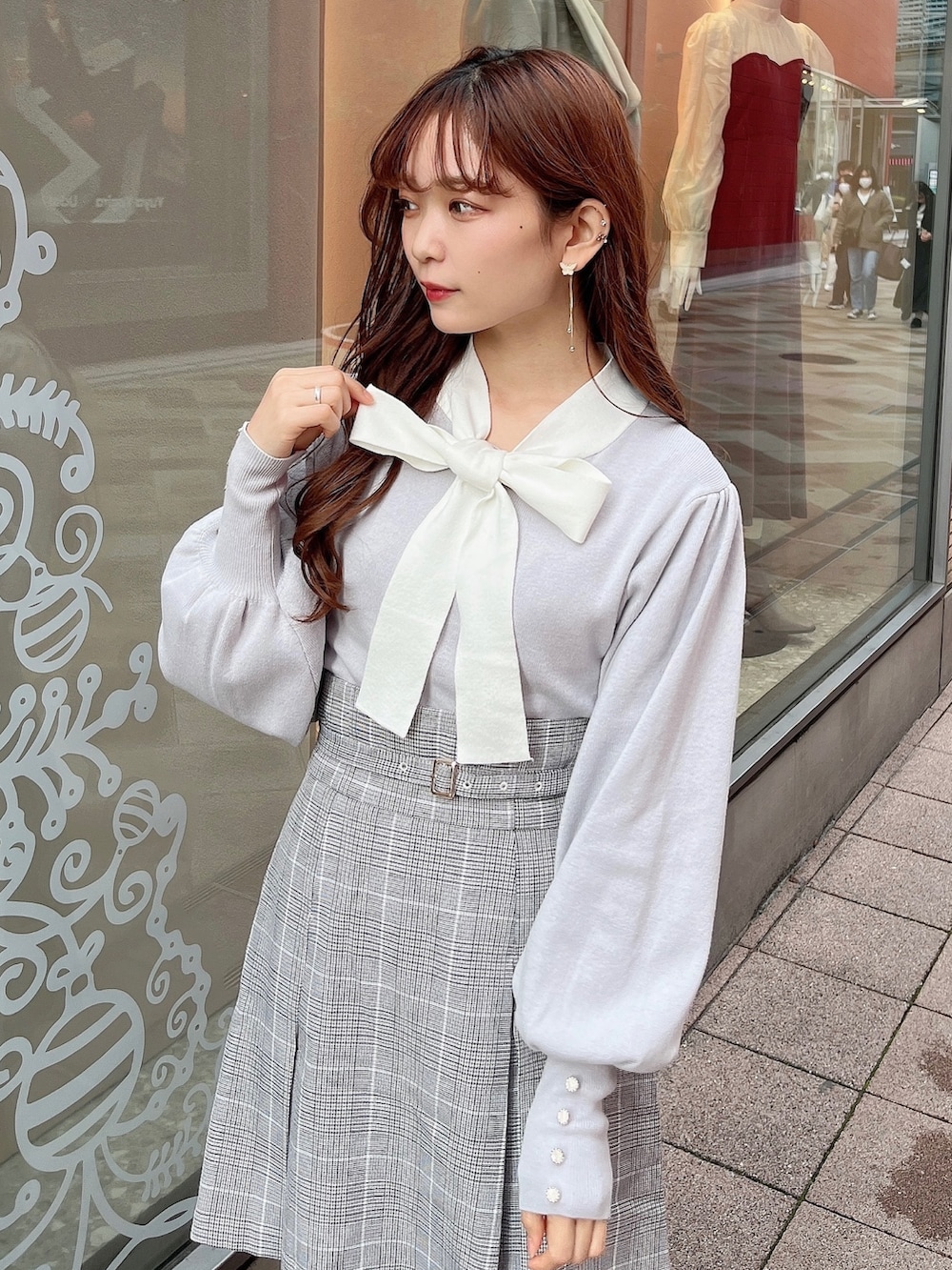 グレー系のニット/セーター、グレー系のスカート、ベージュ系のブーツを着用したレディースの冬コーディネートの6枚目の写真