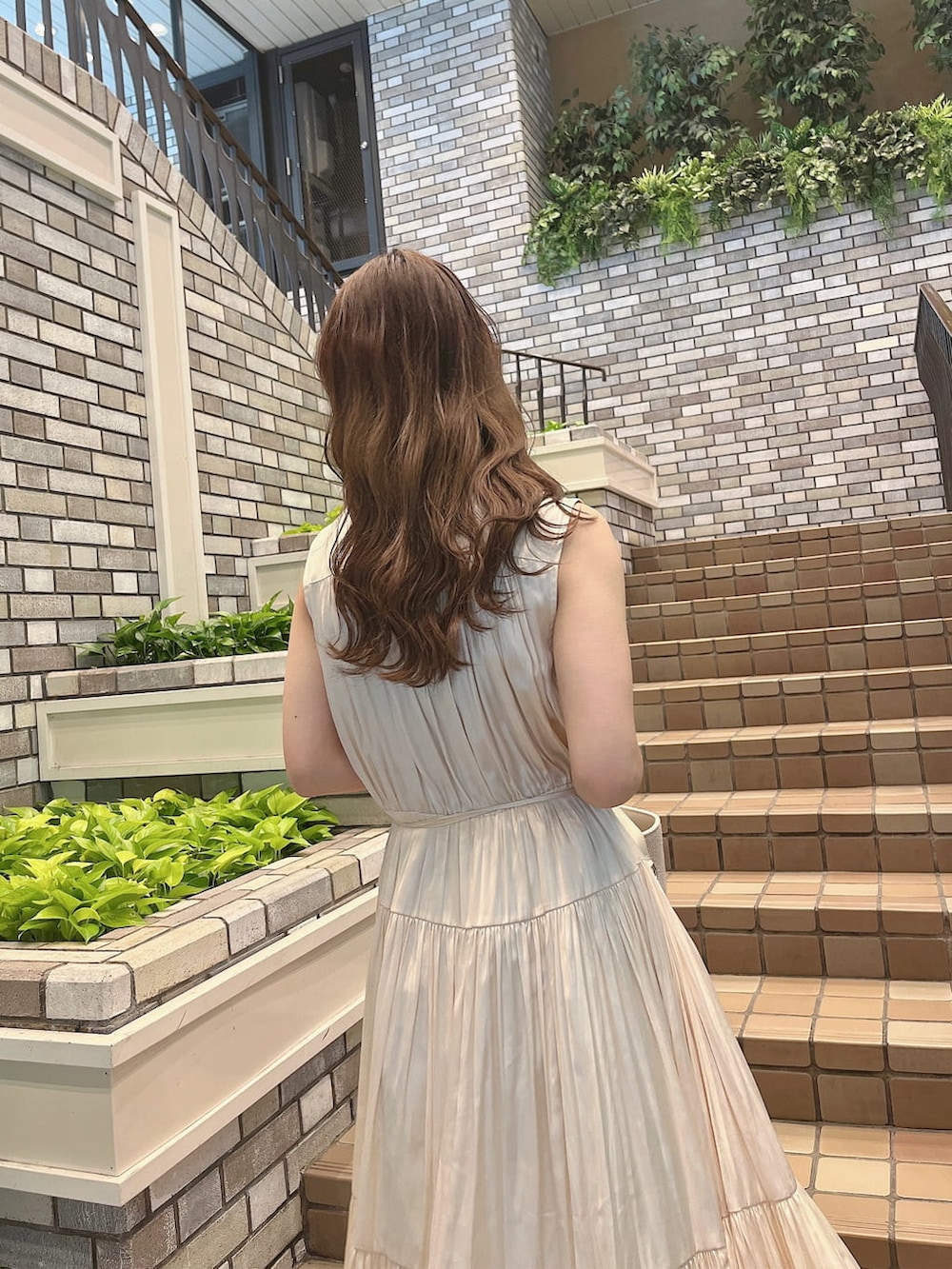 ベージュ系のトレンチコート、ホワイト系のワンピース、ホワイト系のパンプスを着用したレディースの冬コーディネートの3枚目の写真
