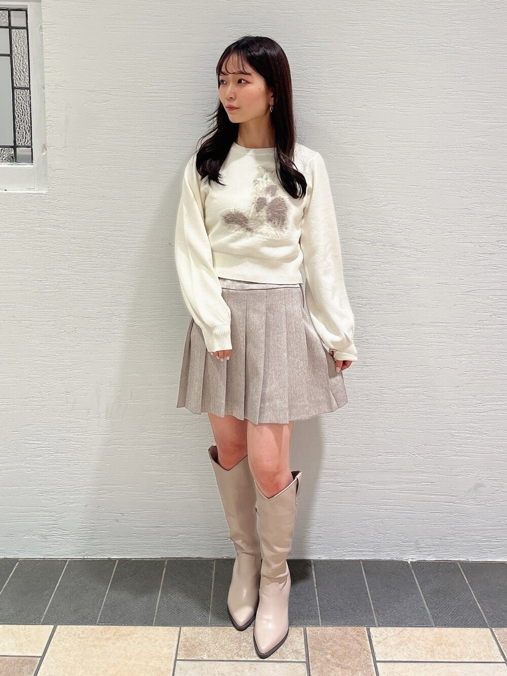 ホワイト系のニット/セーター、ベージュ系のスカート、ベージュ系のブーツを着用したレディースの冬コーディネートの5枚目の写真