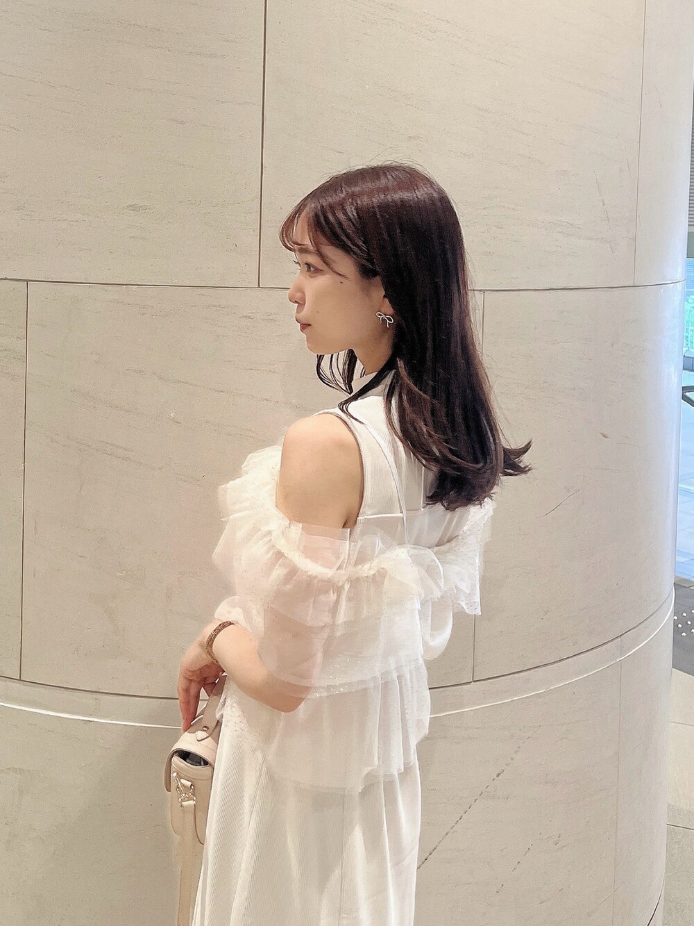 ホワイト系のワンピース、ホワイト系のパンプス、ホワイト系のハンドバッグを着用したレディースの夏コーディネートの7枚目の写真