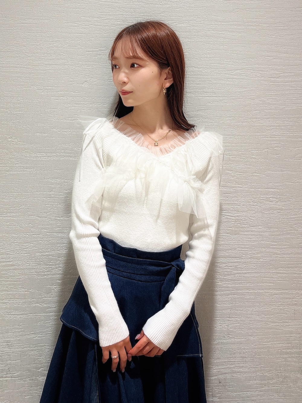 ベージュ系のパンプス、ブルー系のスカート、ホワイト系のニット/セーターを着用したレディースの秋コーディネートの5枚目の写真