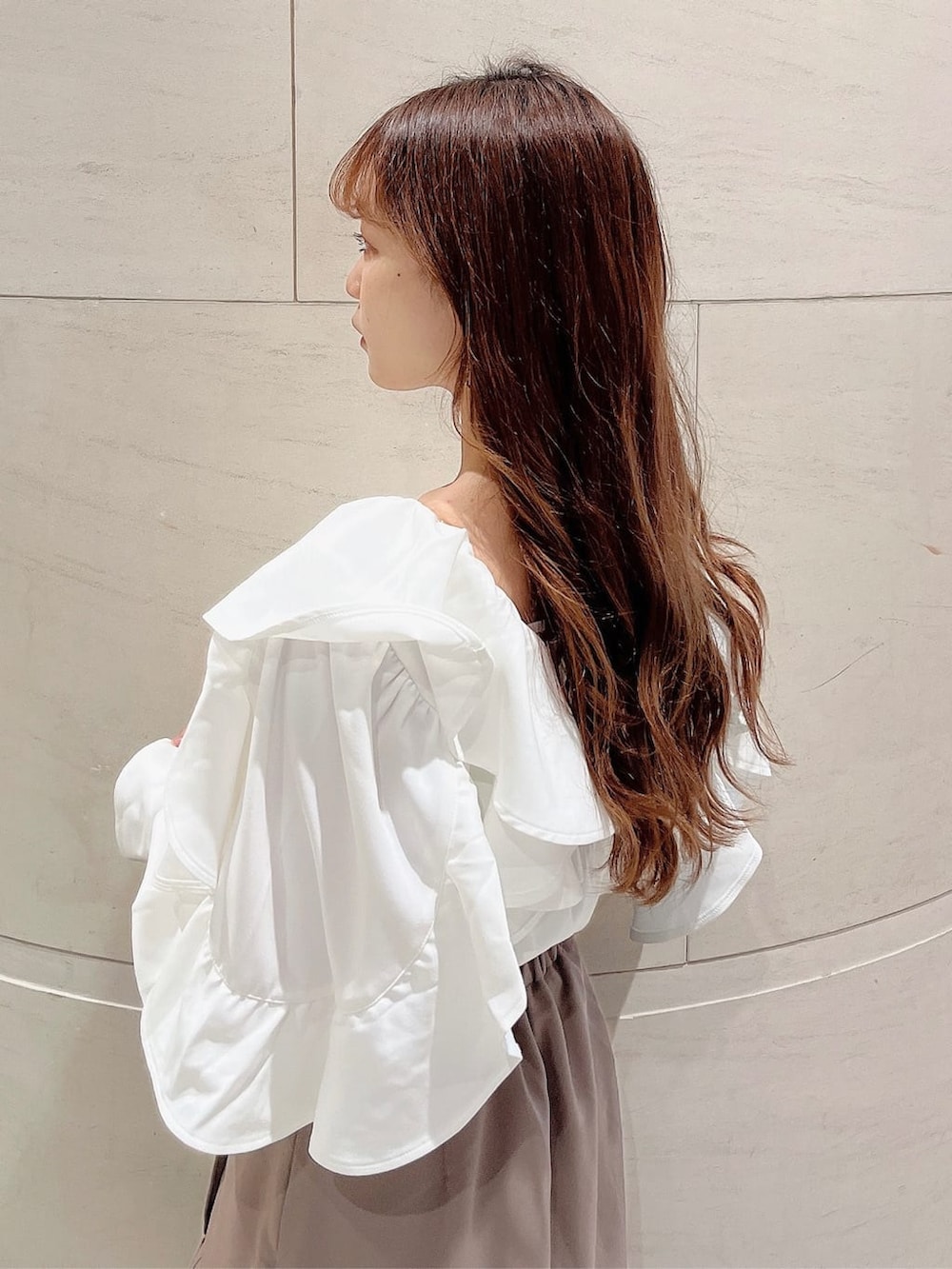 ベージュ系のブーツ、ベージュ系のスカート、ホワイト系のシャツ/ブラウスを着用したレディースの秋コーディネートの6枚目の写真