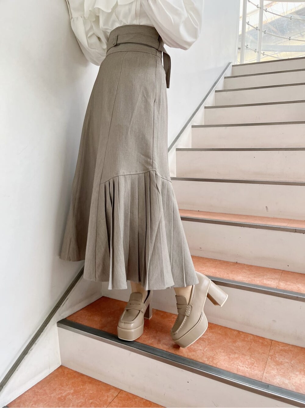 ホワイト系のシャツ/ブラウス、ベージュ系のローファー、ベージュ系のスカートを着用したレディースの冬コーディネートの9枚目の写真