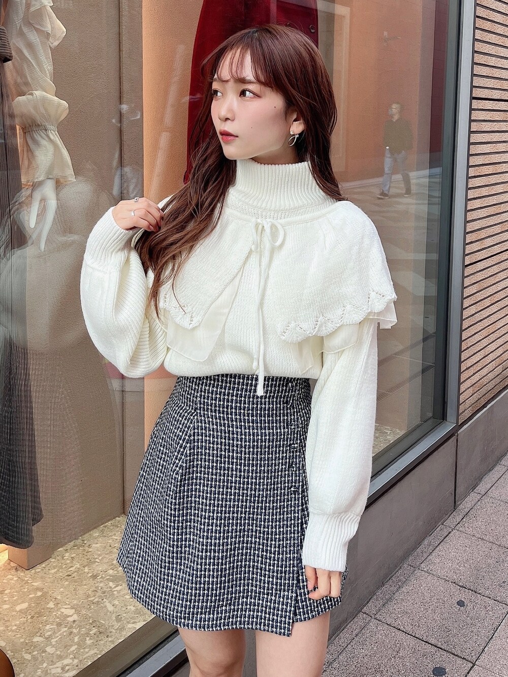 ホワイト系のニット/セーター、ブルー系のスカート、ブラック系のブーツを着用したレディースの秋コーディネートの4枚目の写真