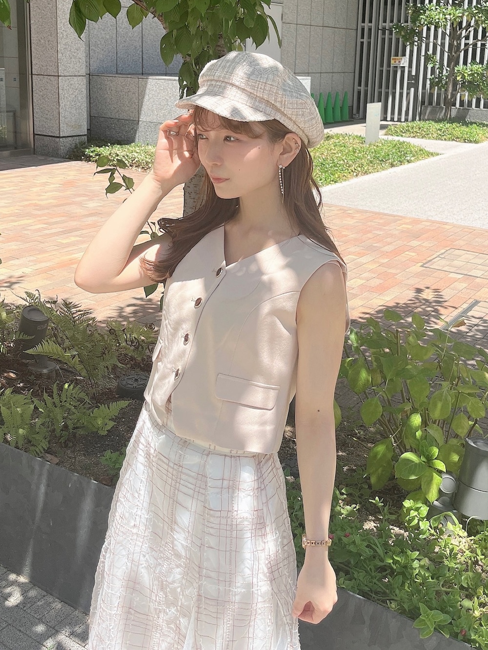 ベージュ系のベスト、ベージュ系のスカート、ホワイト系のローファーを着用したレディースの夏コーディネートの7枚目の写真