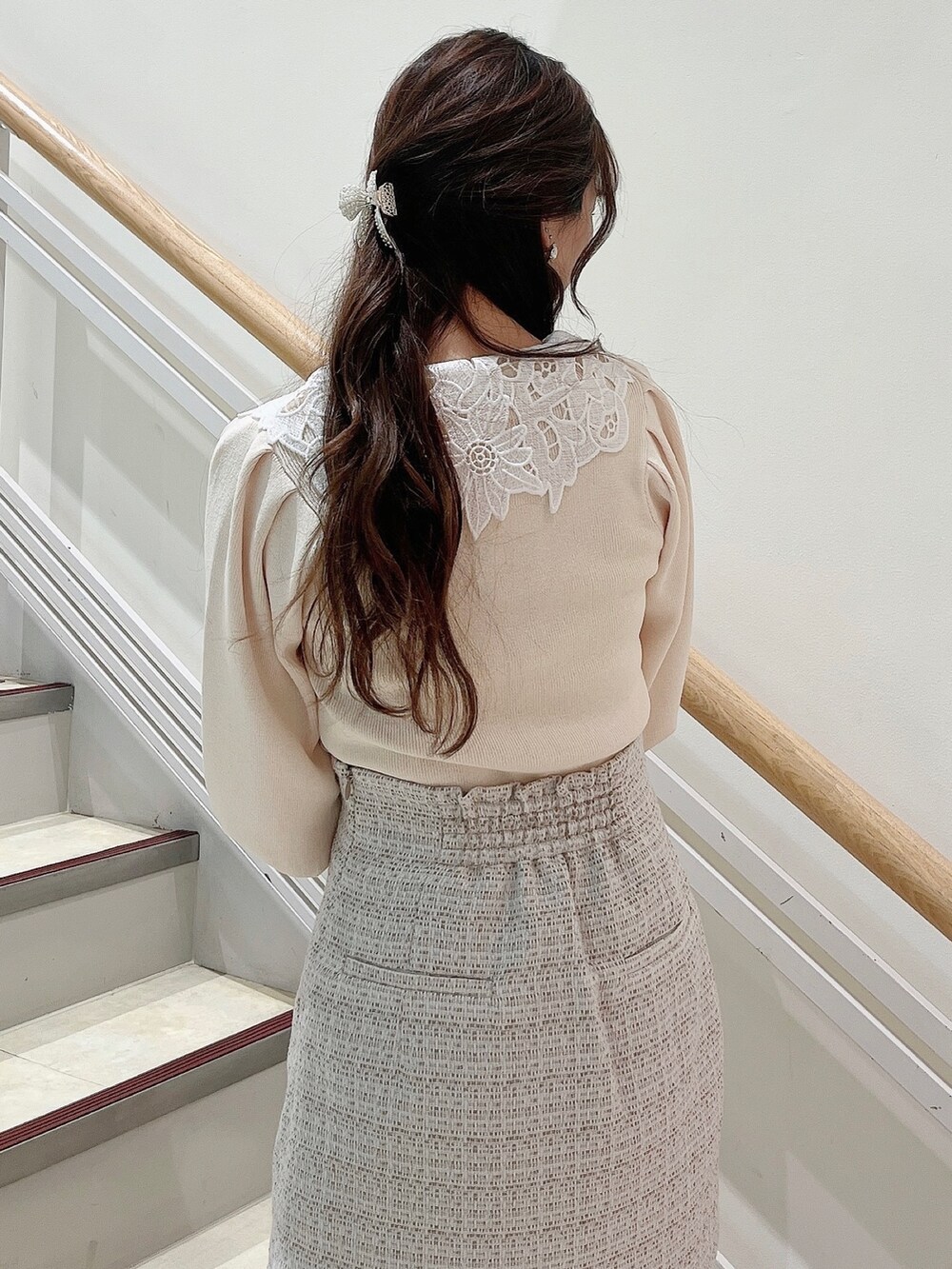 ホワイト系のニット/セーター、ホワイト系のスカート、ベージュ系のブーツを着用したレディースの冬コーディネートの6枚目の写真