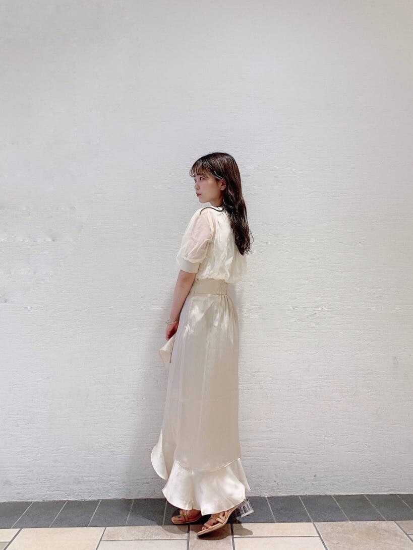 ホワイト系のスカート、ホワイト系のニット/セーター、オレンジ系のサンダルを着用したレディースの夏コーディネートの3枚目の写真