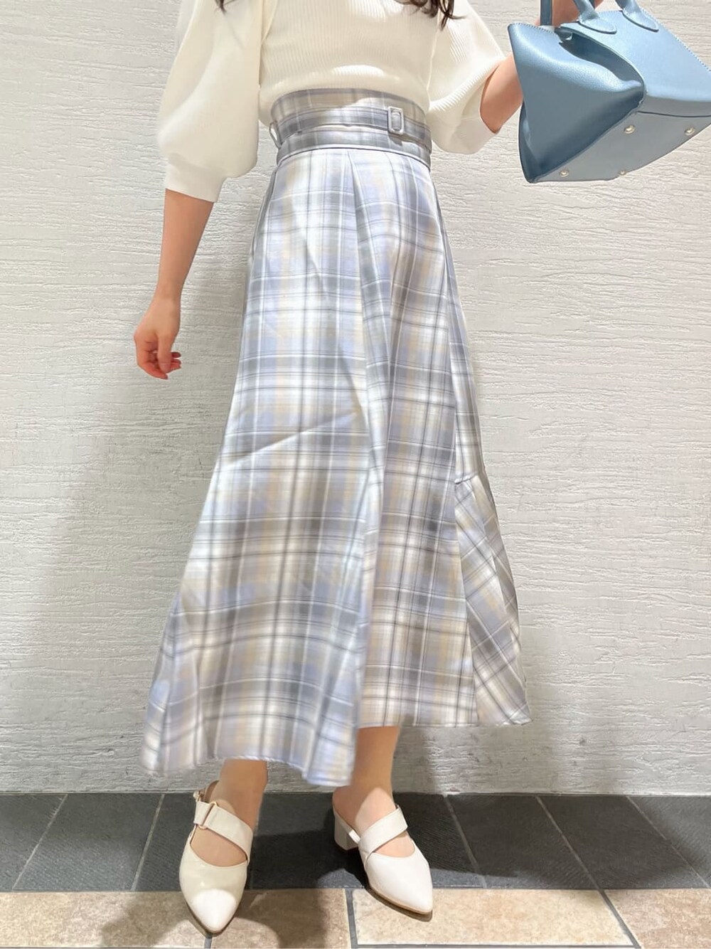 ホワイト系のニット/セーター、ホワイト系のパンプス、その他のスカートを着用したレディースの冬コーディネートの9枚目の写真