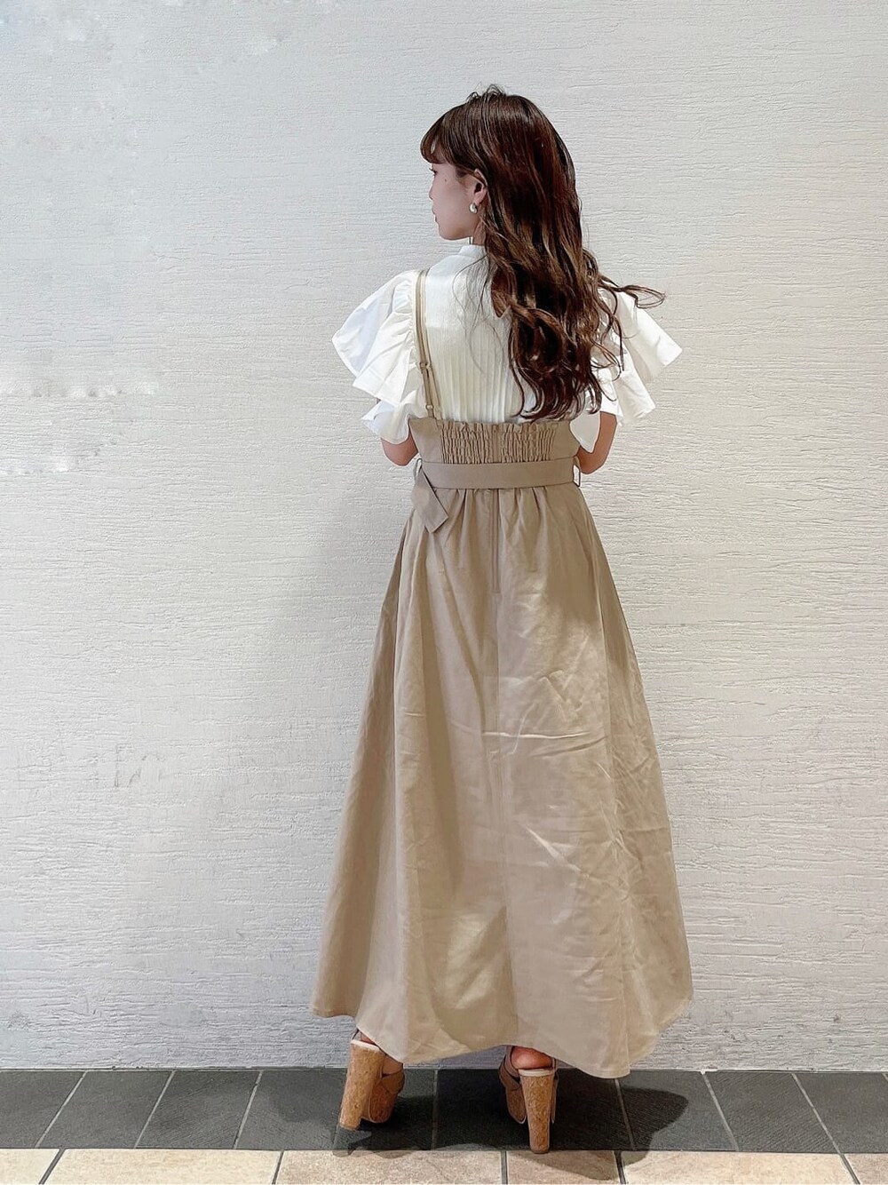 ベージュ系のサンダル、ベージュ系のワンピース、ホワイト系のTシャツ/カットソーを着用したレディースの春コーディネートの3枚目の写真