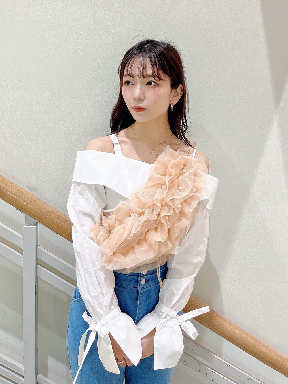 オレンジ系のベスト、ブルー系のデニムパンツ、ホワイト系のシャツ/ブラウスを着用したレディースの春コーディネートの9枚目の写真