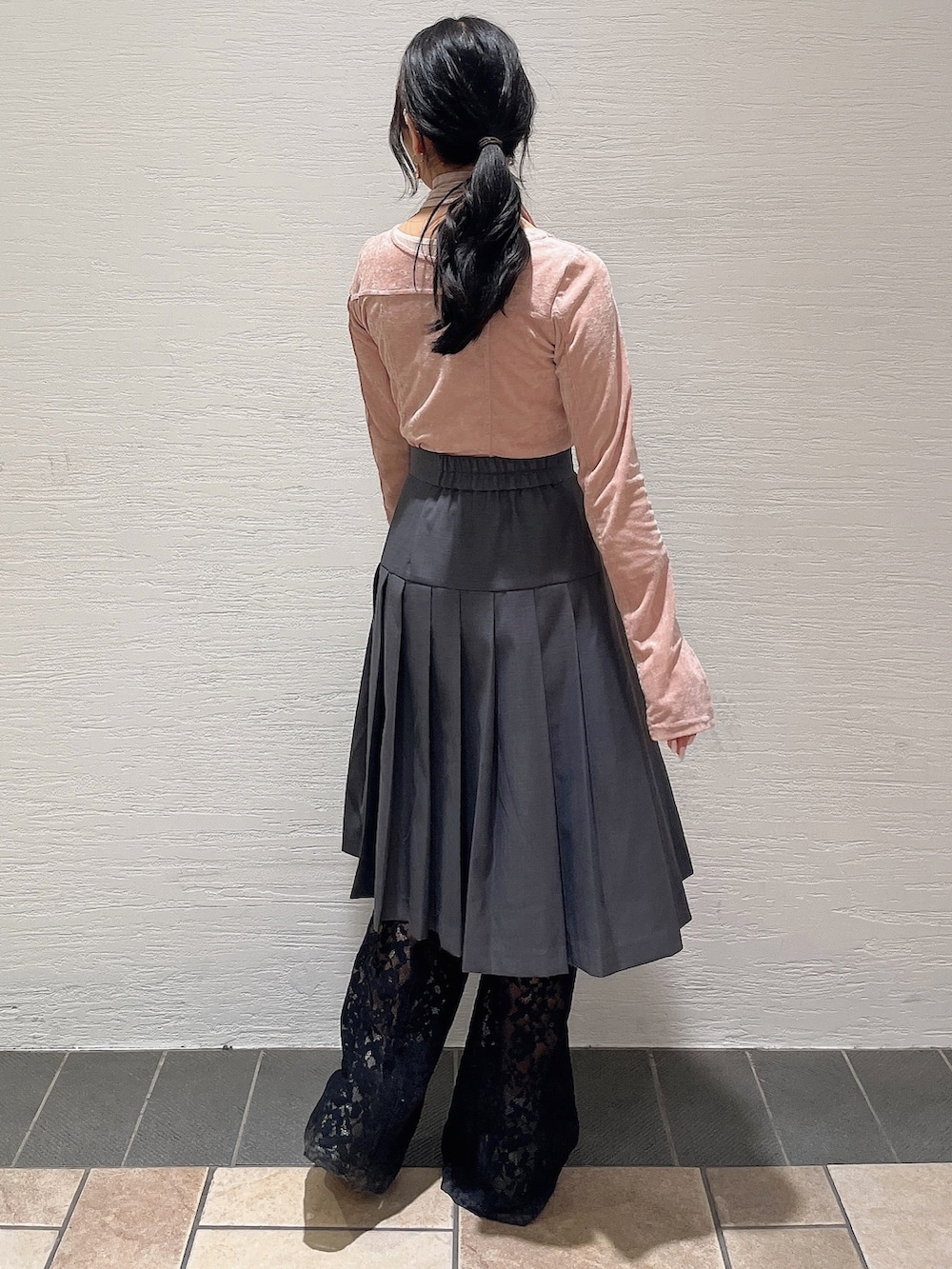 ピンク系のTシャツ/カットソー、グレー系のスカート、ブラック系のその他パンツを着用したレディースの冬コーディネートの4枚目の写真
