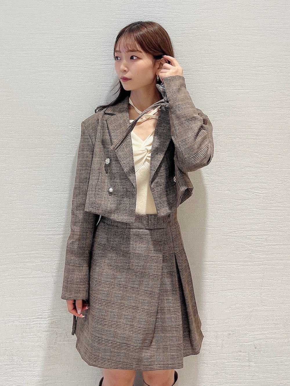 ベージュ系のブーツ、ブラウン系のスカート、ホワイト系のニット/セーターを着用したレディースの秋コーディネートの5枚目の写真