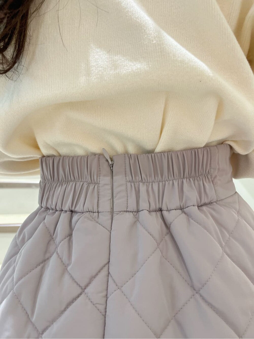 ホワイト系のニット/セーター、ピンク系のスカート、ベージュ系のブーツを着用したレディースの秋コーディネートの10枚目の写真