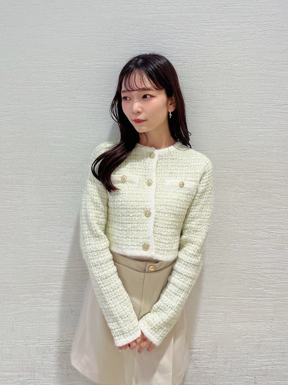 グリーン系のノーカラージャケット、ホワイト系のブーツ、ホワイト系のスカートを着用したレディースの冬コーディネートの5枚目の写真