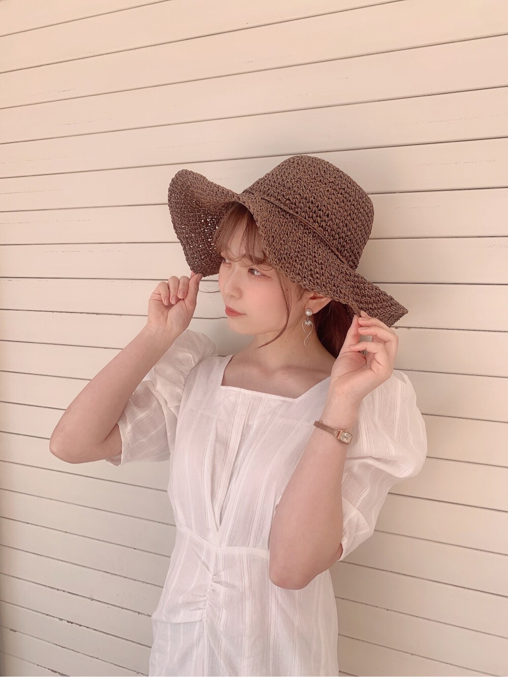 ホワイト系のワンピース、ベージュ系のサンダル、ブラウン系のハットを着用したレディースの春コーディネートの8枚目の写真