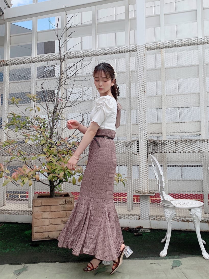 ベージュ系のスカート、ホワイト系のTシャツ/カットソー、ブラウン系のサンダルを着用したレディースの夏コーディネートの2枚目の写真