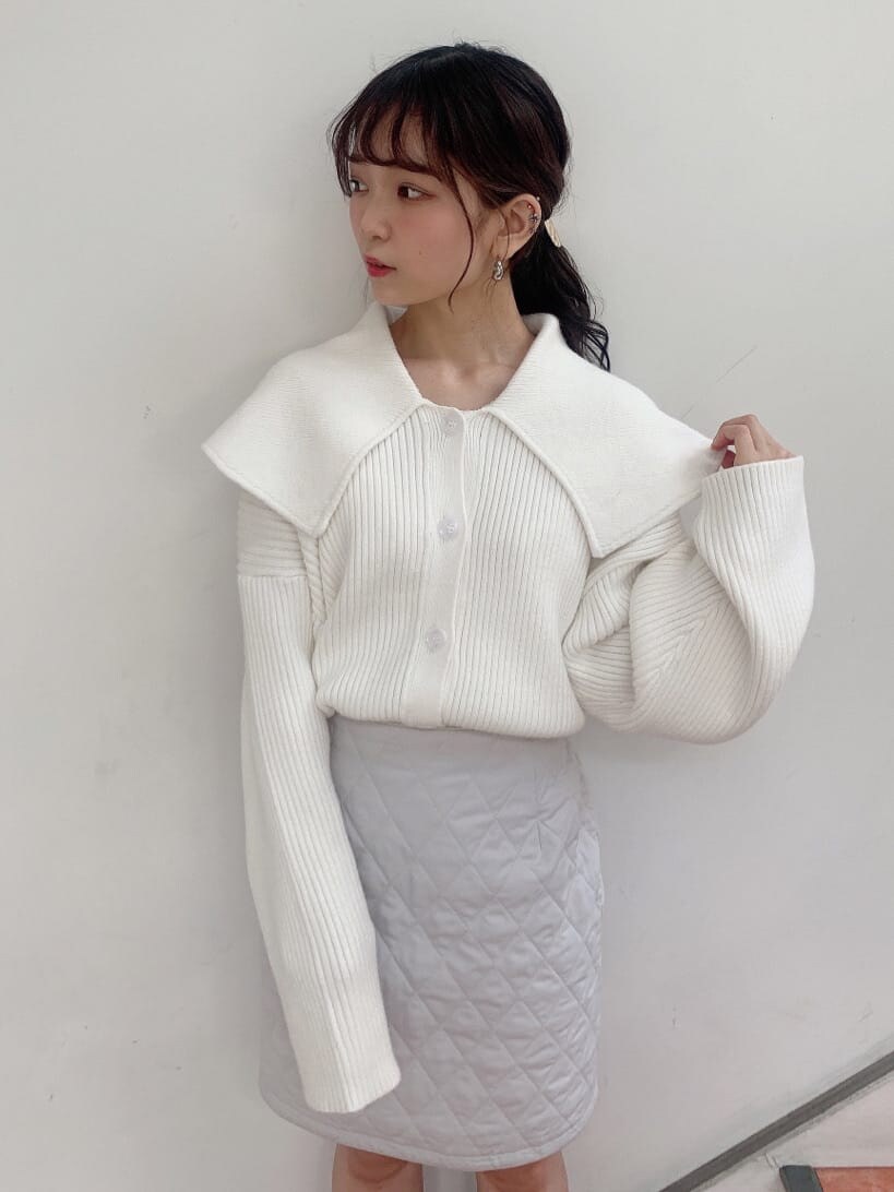 グレー系のスカート、グレー系のブーツ、ホワイト系のニット/セーターを着用したレディースの秋コーディネートの4枚目の写真