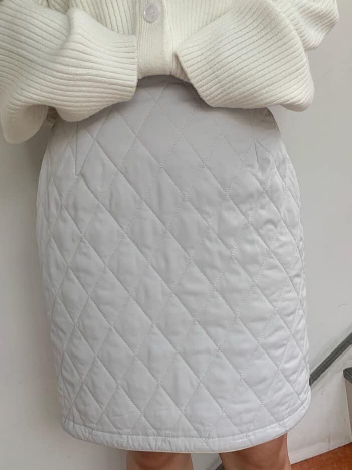 グレー系のスカート、グレー系のブーツ、ホワイト系のニット/セーターを着用したレディースの秋コーディネートの9枚目の写真