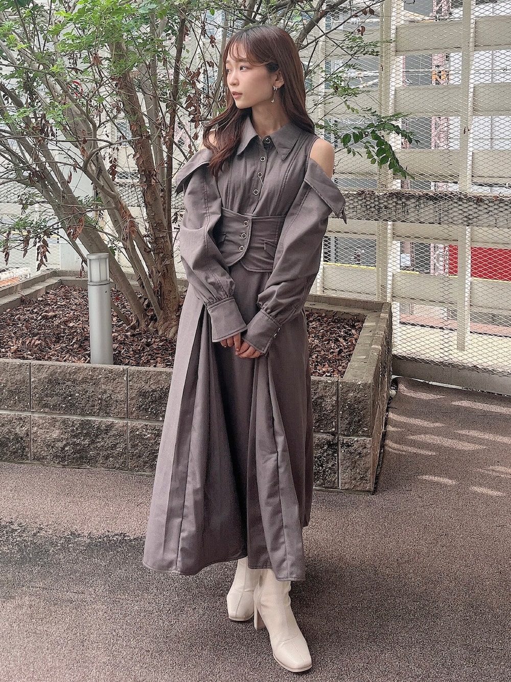 グレー系のワンピース、ホワイト系のブーツを着用したレディースの秋コーディネートの3枚目の写真