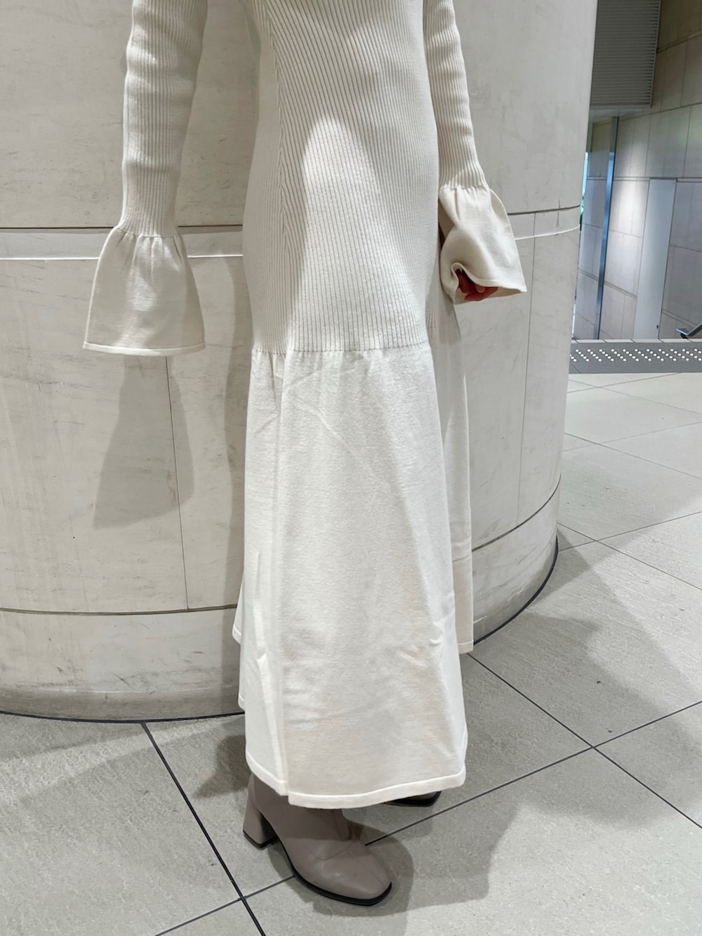 ホワイト系のワンピース、ベージュ系のブーツを着用したレディースの秋コーディネートの10枚目の写真