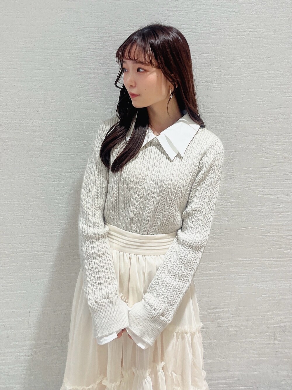 ベージュ系のニット/セーター、ホワイト系のスカート、ベージュ系のブーツを着用したレディースの冬コーディネートの5枚目の写真