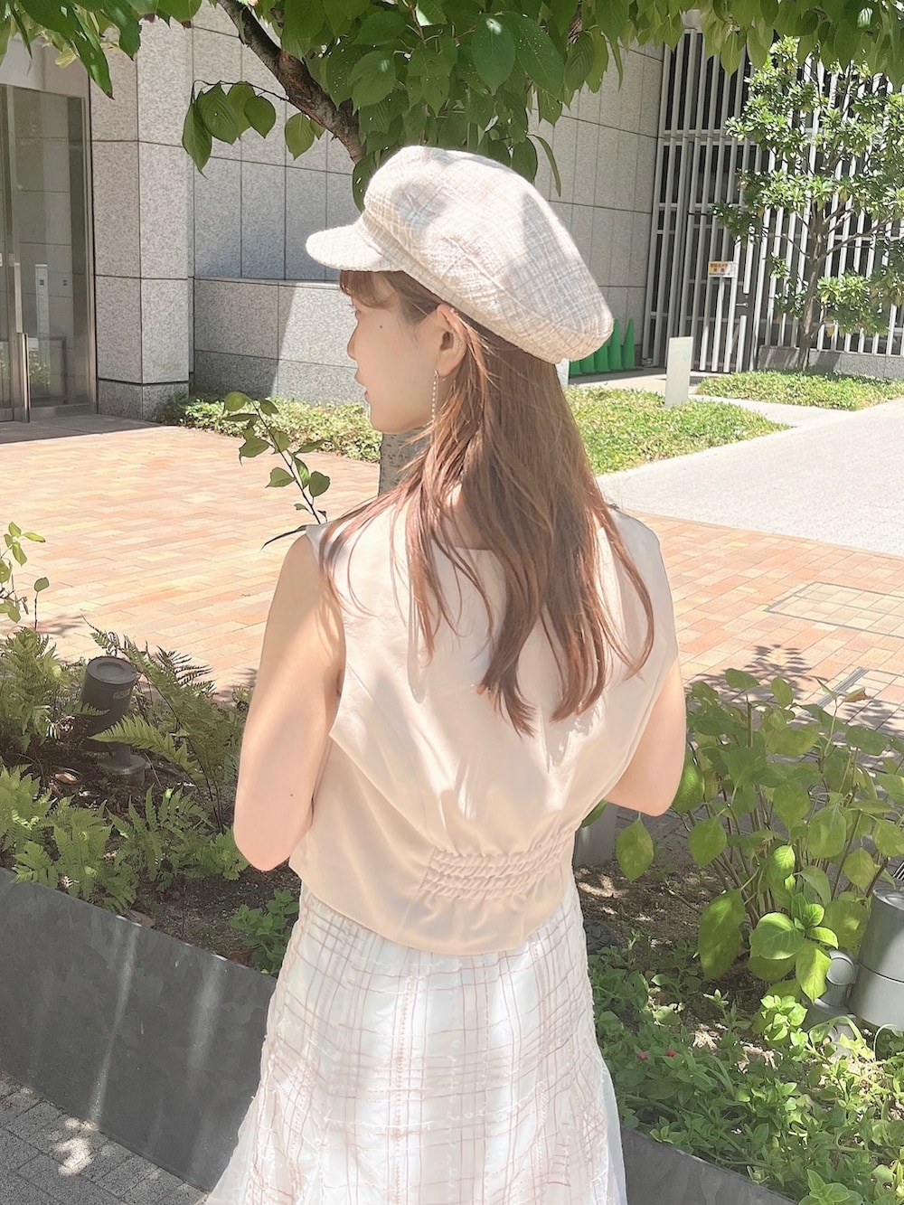 ベージュ系のベスト、ベージュ系のスカート、ホワイト系のローファーを着用したレディースの夏コーディネートの8枚目の写真