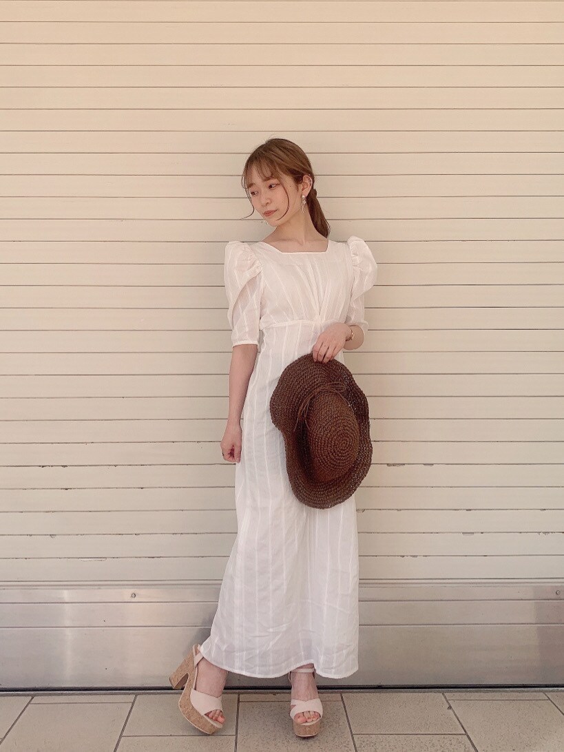ホワイト系のワンピース、ベージュ系のサンダル、ブラウン系のハットを着用したレディースの春コーディネートの2枚目の写真