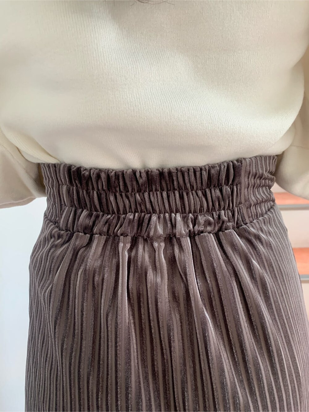 ホワイト系のニット/セーター、ブラウン系のブーツ、ベージュ系のスカートを着用したレディースの秋コーディネートの9枚目の写真