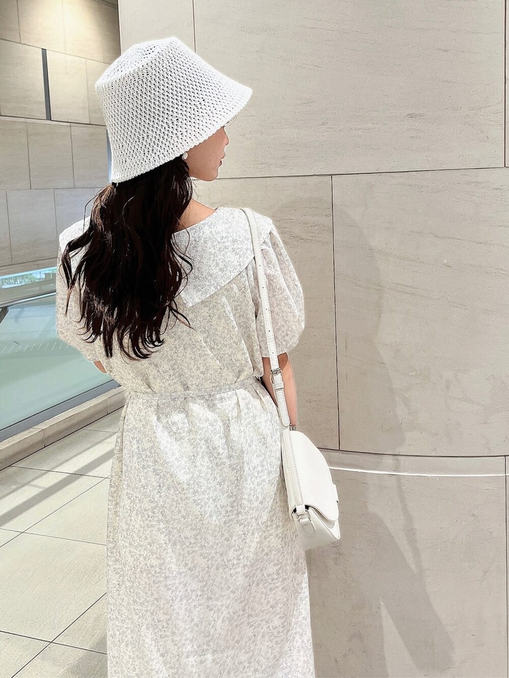 ベージュ系のサンダル、ホワイト系のワンピース、ホワイト系のハットを着用したレディースの春コーディネートの6枚目の写真
