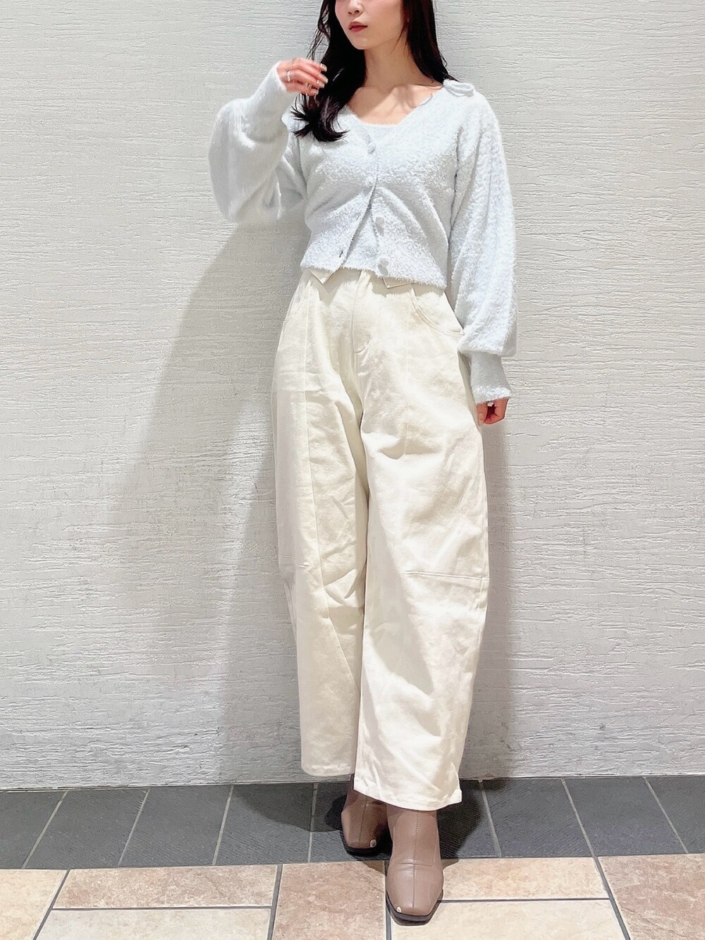 グレー系のキャミソール、グレー系のカーディガン/ボレロ、ホワイト系のデニムパンツを着用したレディースの冬コーディネートの3枚目の写真