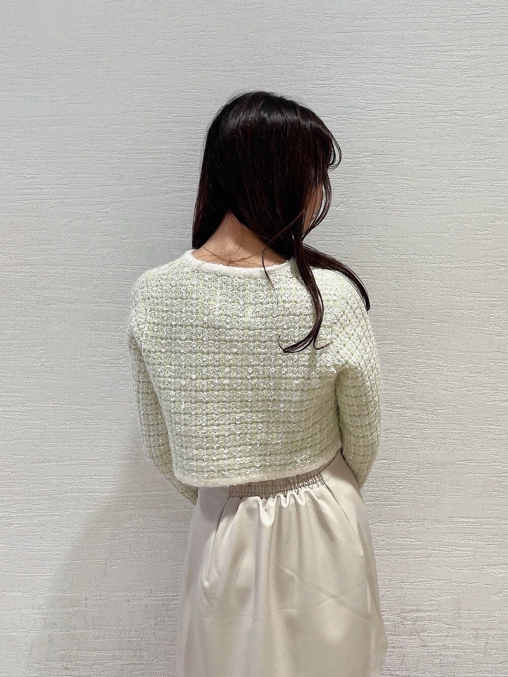 グリーン系のノーカラージャケット、ホワイト系のブーツ、ホワイト系のスカートを着用したレディースの冬コーディネートの8枚目の写真