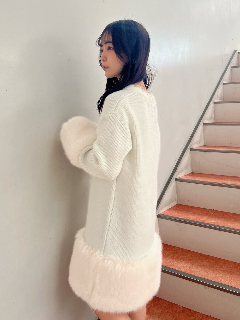 ベージュ系のブーツ、ホワイト系のワンピースを着用したレディースの冬コーディネートの6枚目の写真