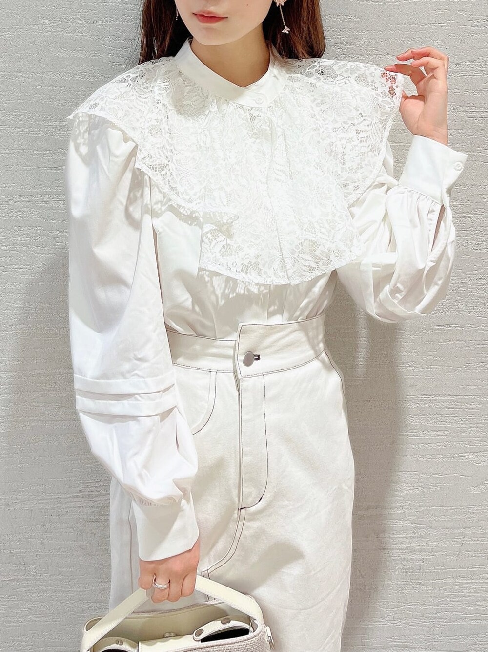 ホワイト系のシャツ/ブラウス、ホワイト系のパンプス、ホワイト系のハンドバッグを着用したレディースの春コーディネートの4枚目の写真