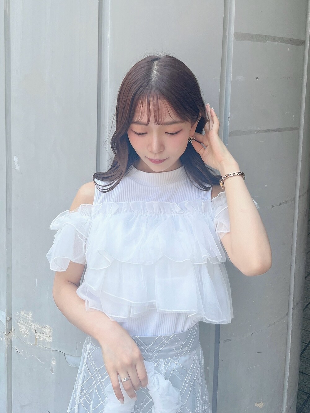 ホワイト系のTシャツ/カットソー、ホワイト系のパンプス、グレー系のスカートを着用したレディースの夏コーディネートの4枚目の写真