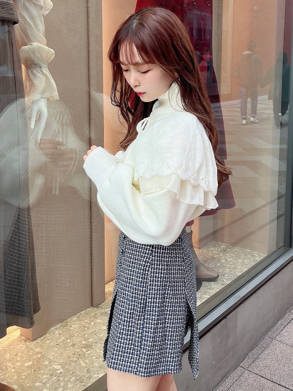 ホワイト系のニット/セーター、ブルー系のスカート、ブラック系のブーツを着用したレディースの秋コーディネートの5枚目の写真