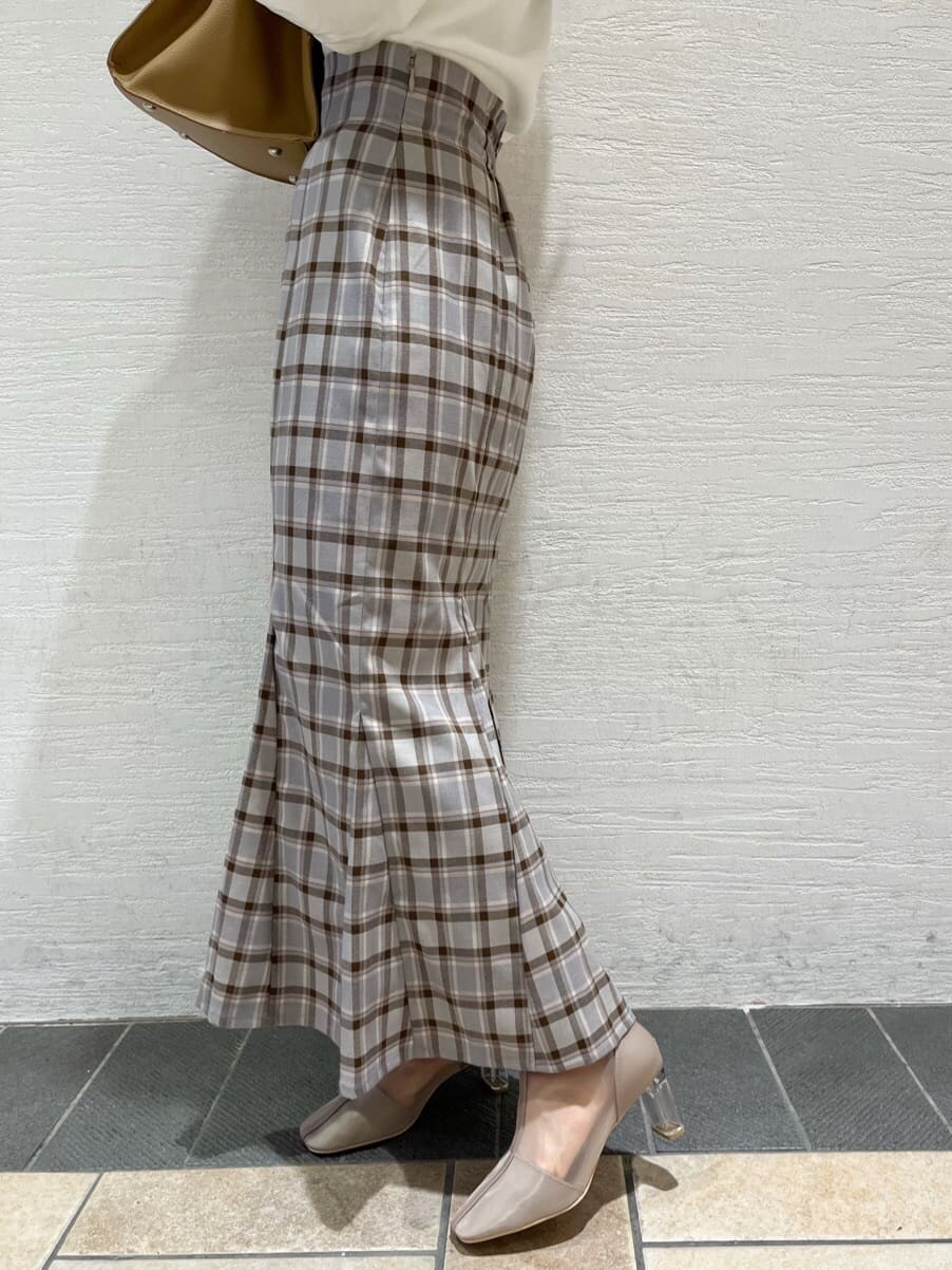 ベージュ系のブーツ、グレー系のスカート、ホワイト系のニット/セーターを着用したレディースの冬コーディネートの8枚目の写真