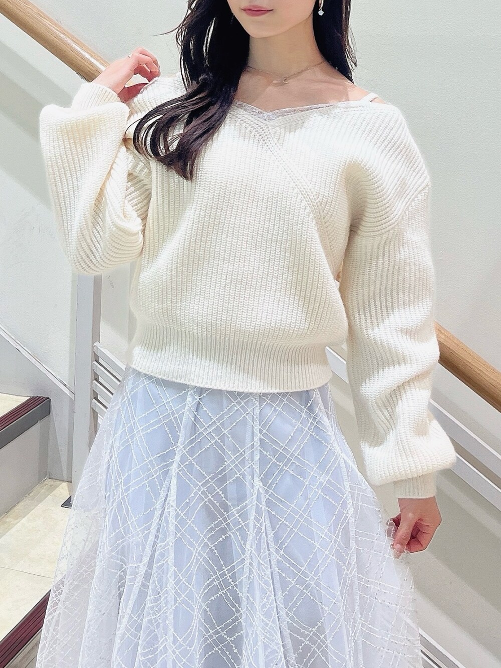 ホワイト系のニット/セーター、グレー系のスカート、ベージュ系のブーツを着用したレディースの冬コーディネートの6枚目の写真