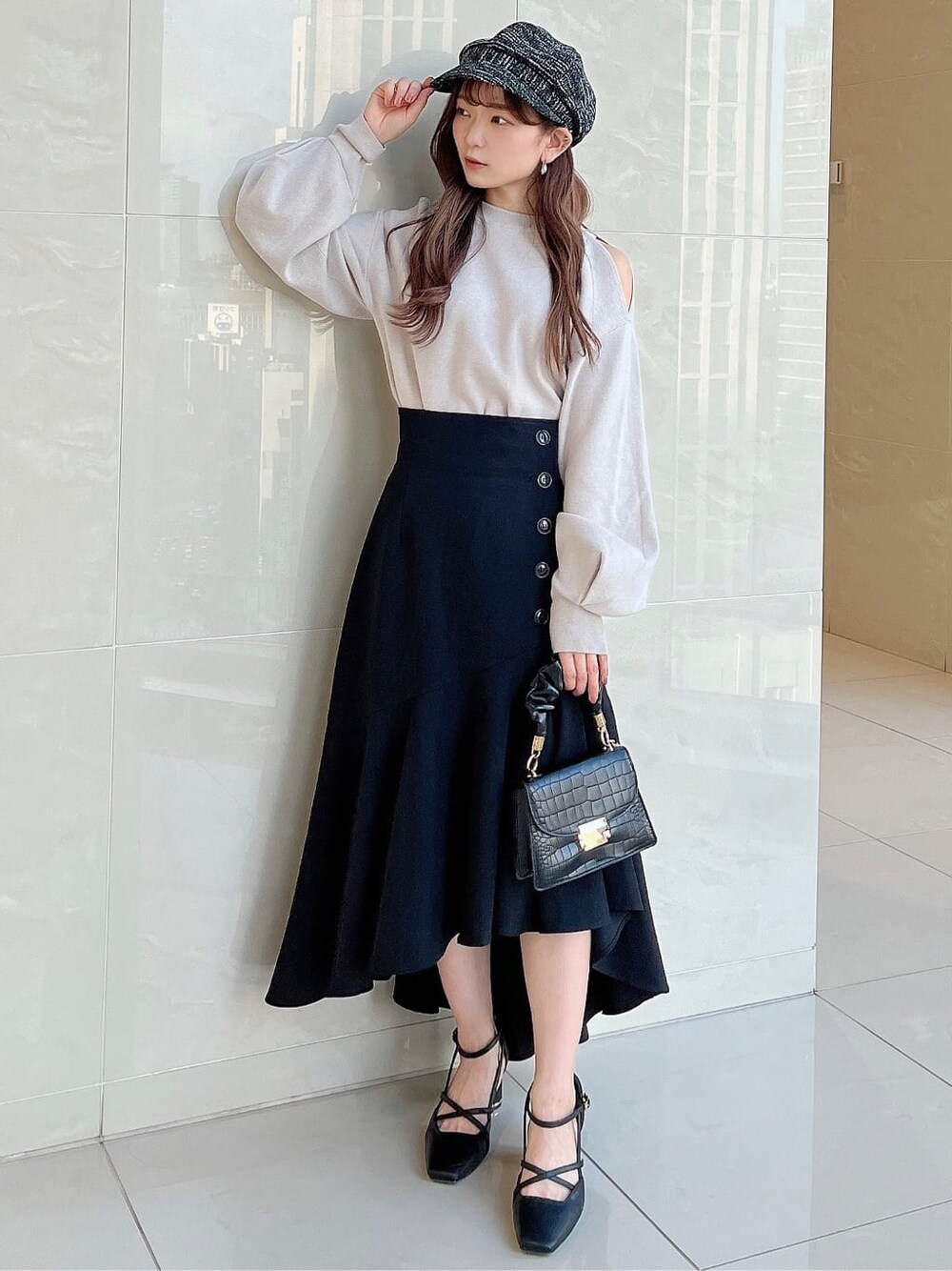 グレー系のニット/セーター、ブラック系のスカート、ブラック系のパンプスを着用したレディースの夏コーディネートの2枚目の写真
