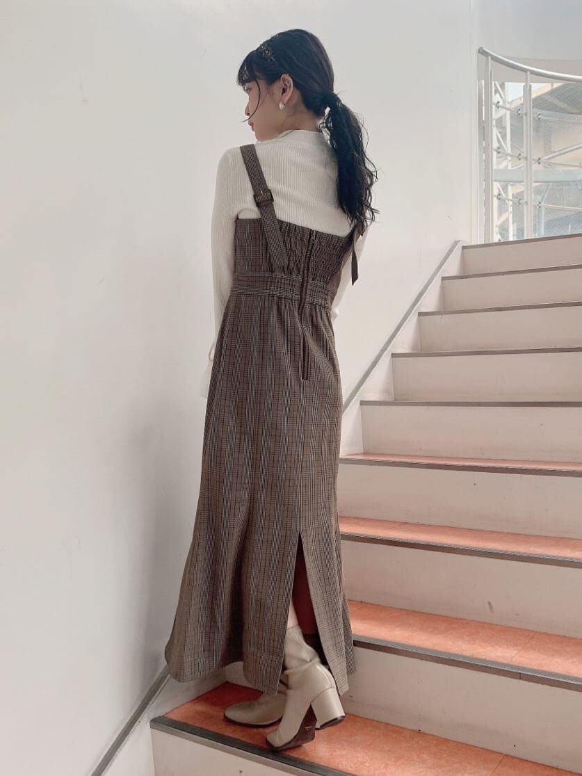 ベージュ系のトレンチコート、ベージュ系のブーツ、その他のジャンパースカートを着用したレディースの秋コーディネートの8枚目の写真