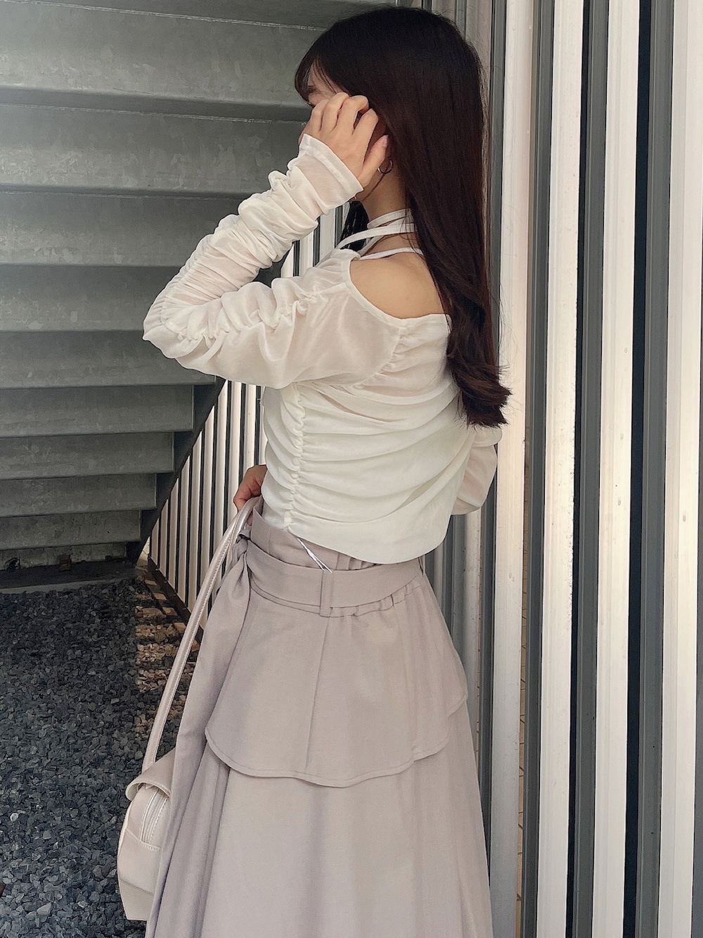 ベージュ系のハンドバッグ、ベージュ系のブーツ、ホワイト系のTシャツ/カットソーを着用したレディースの春コーディネートの6枚目の写真