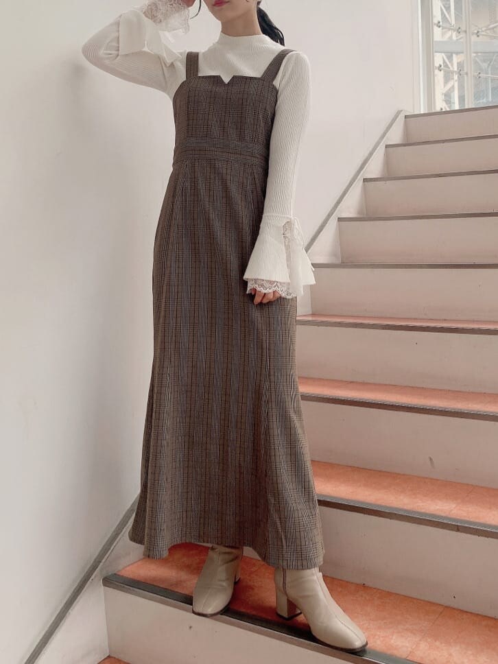 ベージュ系のトレンチコート、ベージュ系のブーツ、その他のジャンパースカートを着用したレディースの秋コーディネートの7枚目の写真