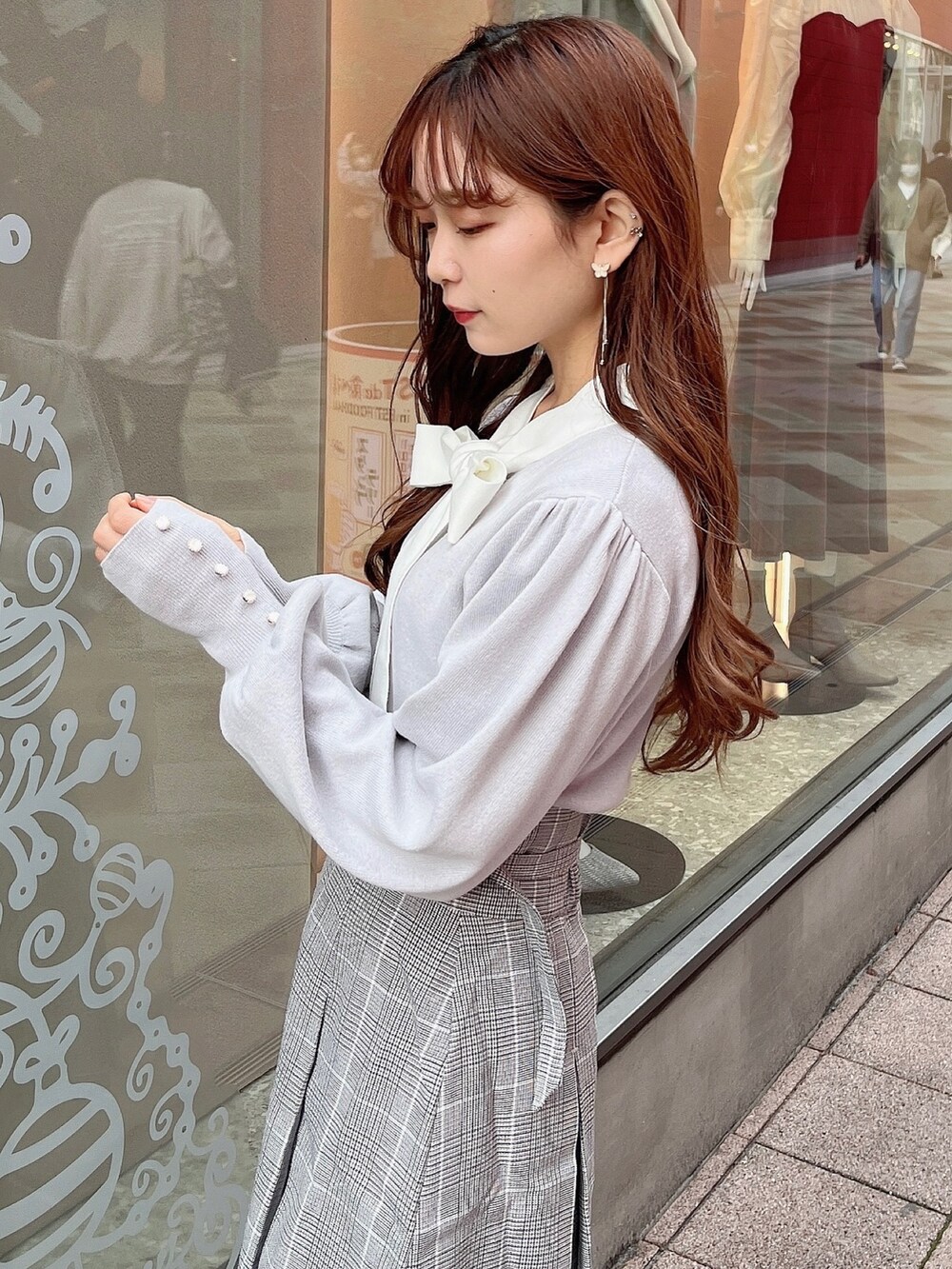 グレー系のニット/セーター、グレー系のスカート、ベージュ系のブーツを着用したレディースの冬コーディネートの7枚目の写真