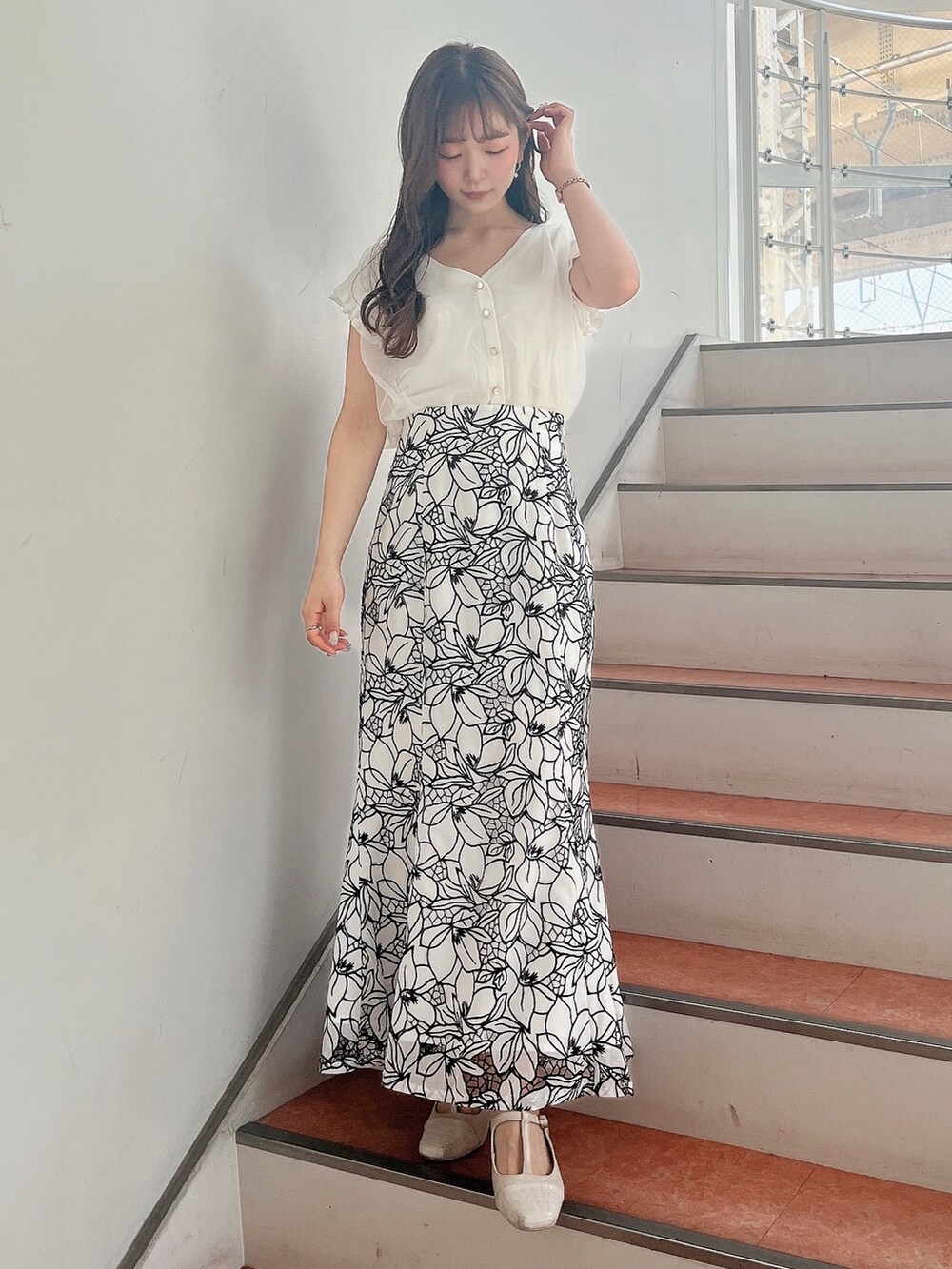 ホワイト系のパンプス、ホワイト系のスカート、ホワイト系のニット/セーターを着用したレディースの春コーディネートの2枚目の写真