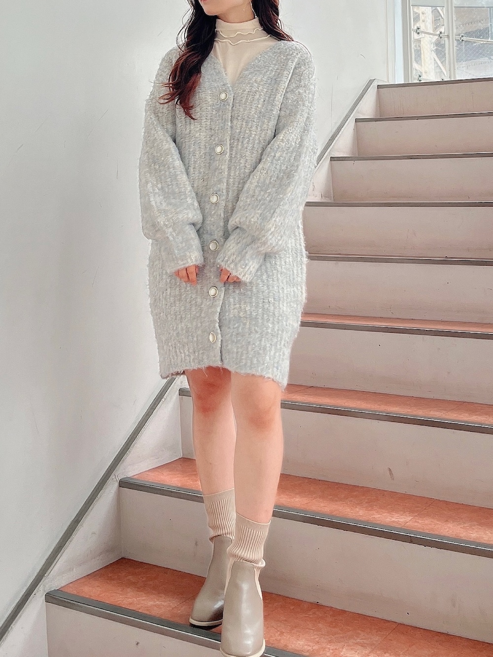 ホワイト系のTシャツ/カットソー、ブルー系のカーディガン/ボレロ、ベージュ系のブーツを着用したレディースの秋コーディネートの2枚目の写真