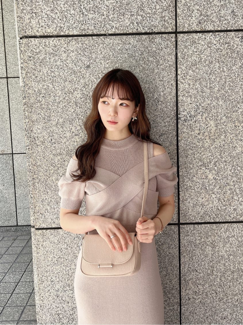 ピンク系のワンピース、ブラック系のブーツ、ホワイト系のショルダーバッグを着用したレディースの冬コーディネートの4枚目の写真