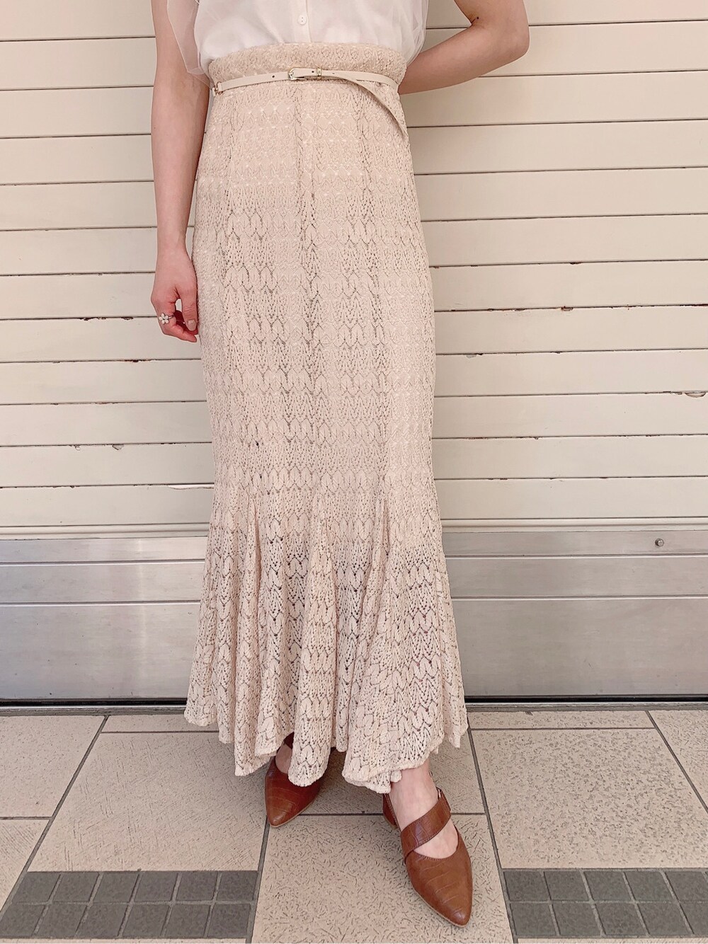 ホワイト系のスカート、ブラウン系のパンプス、ホワイト系のニット/セーターを着用したレディースの春コーディネートの8枚目の写真